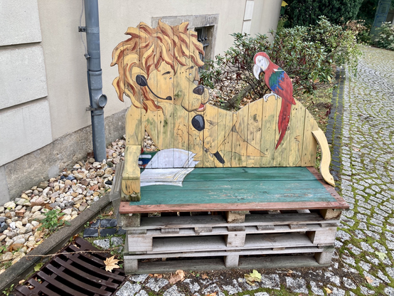 Foto einer Bank hergestellt aus Europaletten bei der die Rückenlehne aus dem Umriss eines gezeichneten Löwen besteht