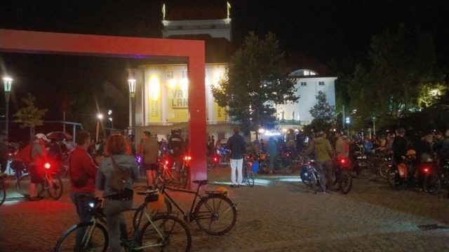 Radfahrer im Dunkeln vor dem erleuchteten Schauspielhaus am Ende der Radnacht.