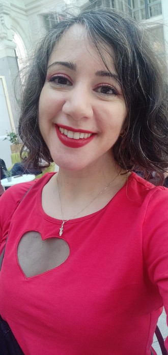 Laura con top rojo y maquillaje de ojos y labios en tonos frambuesa.