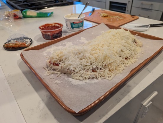 Uncooked pizza on a baking sheet