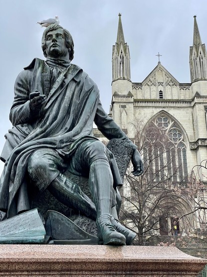 Statue of Robert Burns, with gull perched on head; St Paul’s Cathedral behind