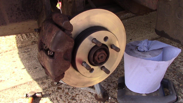 A new brake disc and new brake pads with a crusty looking old brake caliper.  The vehicle they're fitted to is an Austin Maestro.