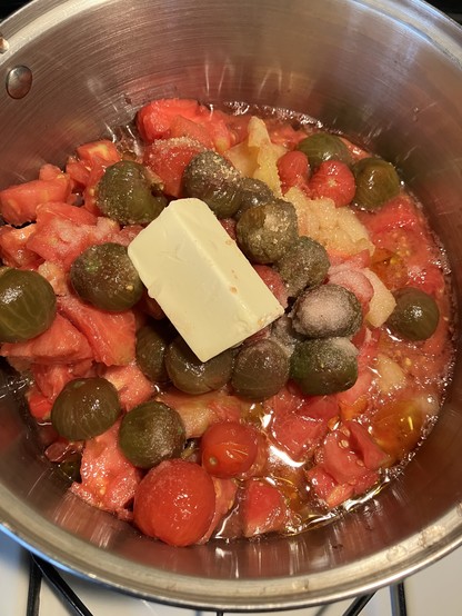 Peeled black cherry, red cherry, yellow, and red tomatoes chunked in a pot, topped with salt, sugar, and a lump of butter. Garlic and onions, my black apron, and loud music not pictured but should be assumed to be present!