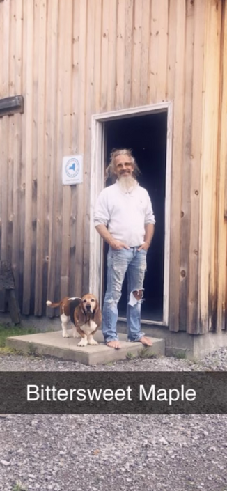Standing in the doorway of the maple syrup sugar house with a beautiful Basset Hound.