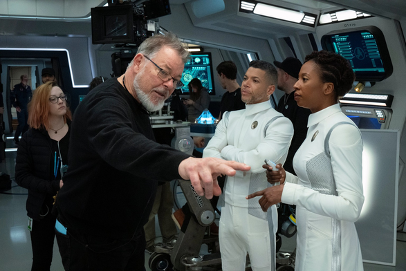 A behind-the-scenes shot with Jonathan Frakes on the left directing Wilson Cruz (middle) and Raven Dauda(RHS) in Star Trek Discovery.