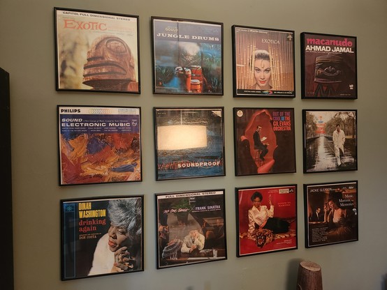 12 framed LP album covers on a wall, which include records by Frank Sinatra, Dinah Washington, Gil Evans, and Ahmad Jamal