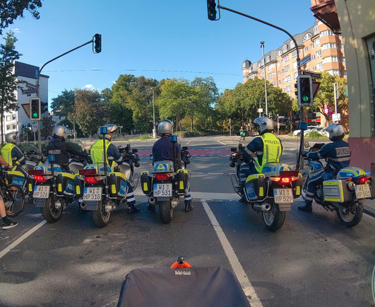 Sechs Polizisten auf MotorrÃ¤dern vor einer groÃŸen Kreuzung
