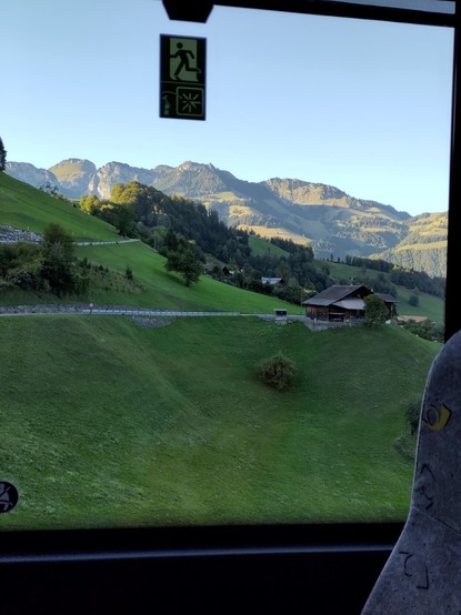 Foto. Blick aus einem Bus-Fenster auf eine Berglandschaft.