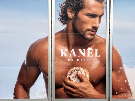 Advertising in Sweden: an attractive male model, like in some perfume ad, holding a cinnamon bun.