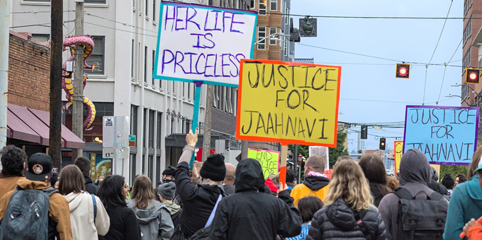 Photo of protesters leaving Union Station, signs seen, Her life is PRICELESS, Justice for Jaahnavi yellow sign, Justice for Jaahnavi blue sign.