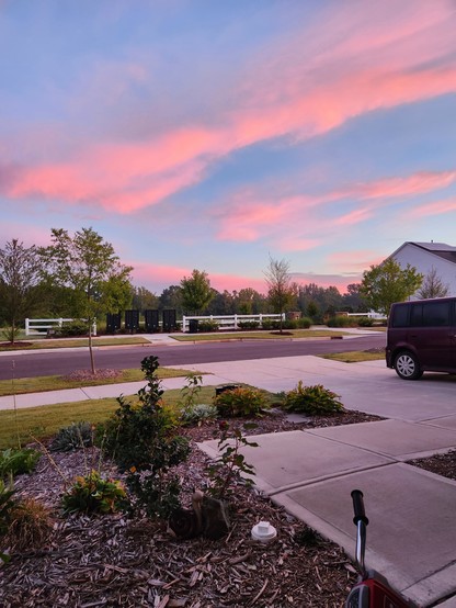 Photo of a sunrise from NC, USA. The sky is a Carolina blue and the clouds are a light pink.