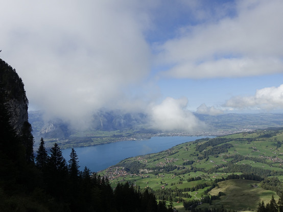 Lake Thun in the center of the image and Thun on the upper coast line. The mountains on the other side of the lake are barely visible due to clouds over the lake.