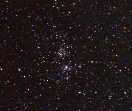 The Double Cluster of colourful stars at centre of frame. Many star dots around them.