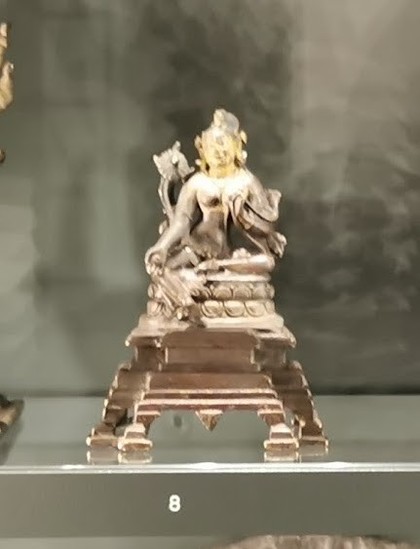 Small statuette of the Indian goddess Tara seated on a small base. Bronze with silver. From the British Museum. The picture is fuzzy, as the deity is wearing jewellery and not much else.