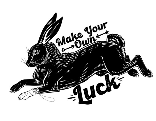 Black and white image of a rabbit running. One of their front paws is a lucky rabbit foot keychain that has been reattached. It says “make your own luck”.