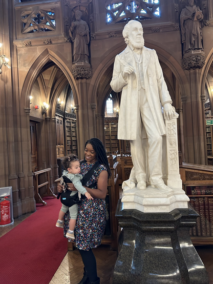 Me and my daughter standing next to the statue of John Ryland