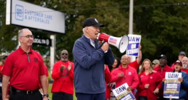 US President Joe Biden talking with a bullhorn in front of the United Auto Workers Union picket line.