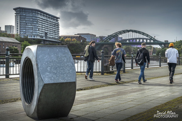 A group of four students walking along the Sunderland riverside, commuting between Sunderland University's campuses, as the new academic years underway.