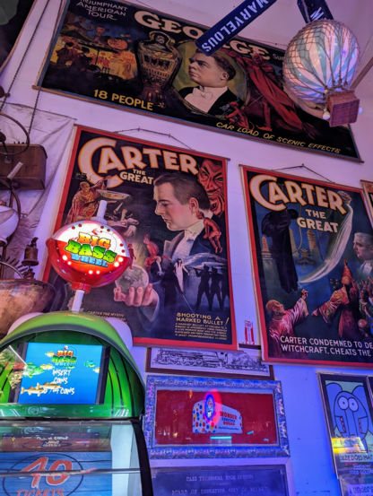 A wall with several colorful and stylistic posters titled "Carter the Great". He appears like a magician in several fantastical scenes.