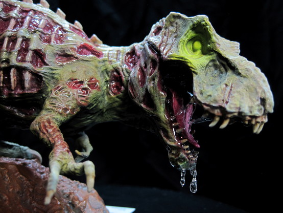 A painted miniature of a zombie t-rex dinosaur. On a black background. Right head view.