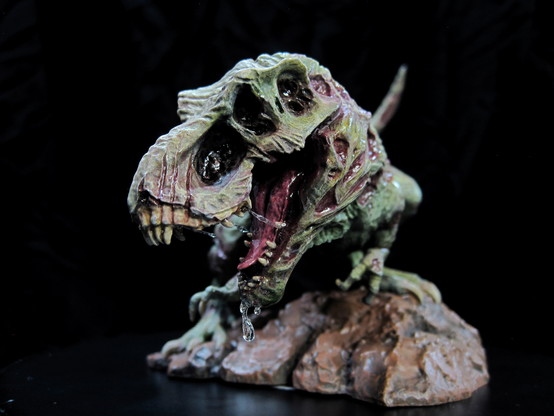 A painted miniature of a zombie t-rex dinosaur. On a black background. Left head view.