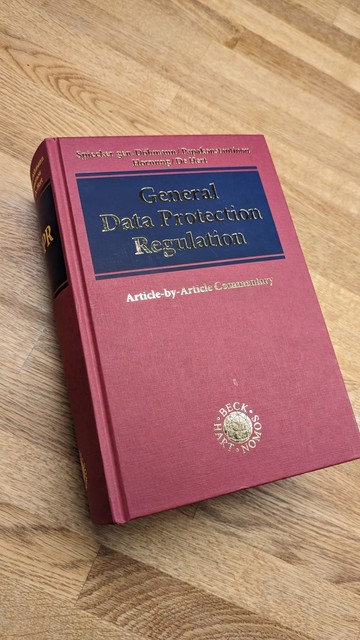 Buch mit weinrotem Einband und dem Titel General Data Protection Regulation auf einem Tisch