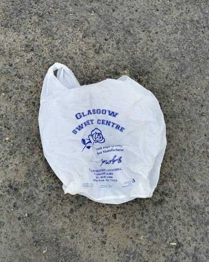 Litter. A plastic bag with the words "Glasgow sweet centre" on it.