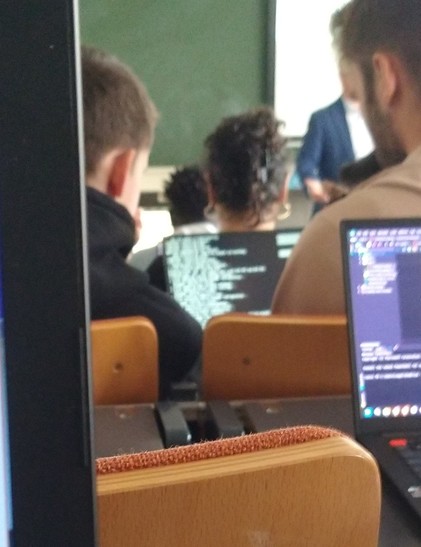 in a lecture hall: a guy with a laptop that's displaying arch linux being installed