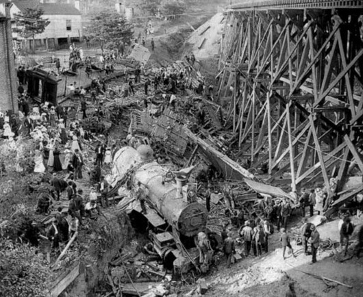 The Wreck of Old 97 at Stillhouse Trestle near Danville, Virginia, 1903. The photograph is believed to have been taken a few days after the occurrence of the wreck as the locomotive, Southern Railway 1102, which had overturned, has been righted. Public Domain, https://commons.wikimedia.org/w/index.php?curid=1043033