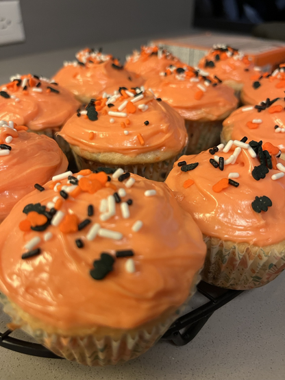 Cupcakes frosted with orange and black bat sprinkles