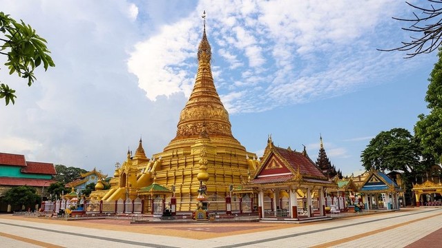 Golden stupa in an ornate temple complex.