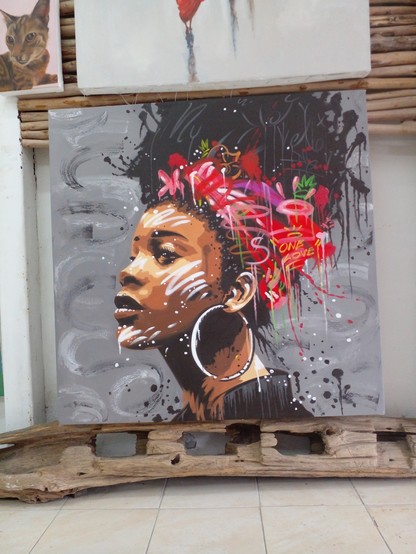 painting of African woman with a scarf wrapped around her hair with lots of splashes of color around her