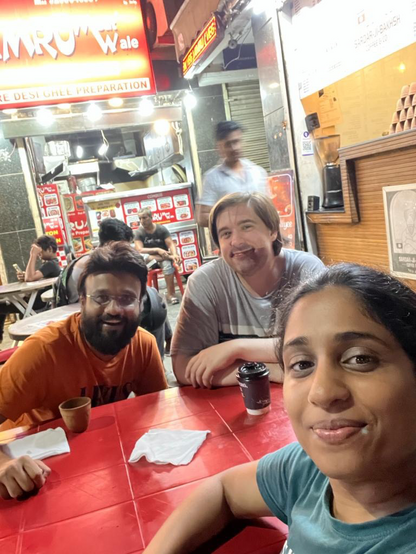 Ruchika's brother, Sean, and Ruchika having a drink at Sardar-ji Baksh at NSP in Delhi. You can see all some of the tangle of small shops with servers behind. The whole complex has many such small shops.