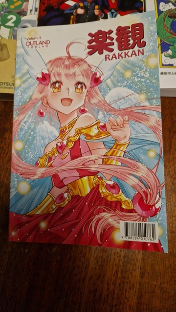Picture of Rakkan 5, a Japanese inspired comic anthology book with local Norwegian artists.
The cover showing a magical girl in pink during a transformation scene.