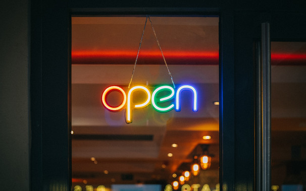 rainbow-colored neon "open" sign in a business window