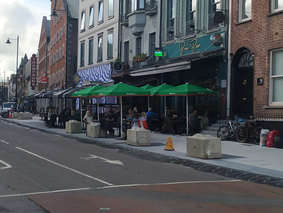 Brú Bar, White Rabbit and Rez obstructing the footpath on MacCurtain Street. Large concrete blocks are intended to prevent illegal parking and loading on the newly-laid footpath.