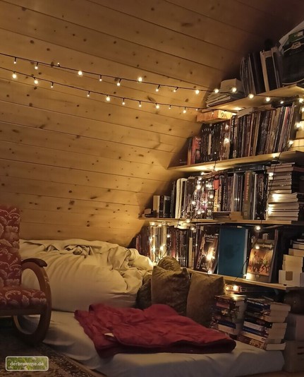 Eine gemÃ¼tliche Leseecke auf einem Dachboden: Eine Matratze, viele Kissen, ein Schaukelstuhl. Im Hintergrund ein Regal voller RollenspielbÃ¼cher. Beleuchtet wird das Ganze von einer Schummrigen LED Lichterkette.