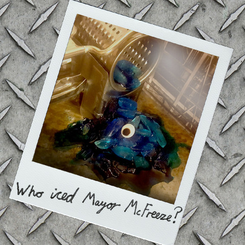 The cover art for Who Iced Mayor McFreeze?, showing a sort of blue ice slurry emerging from a grating machine. The shirt has a conspicuous eyeball embedded in it.