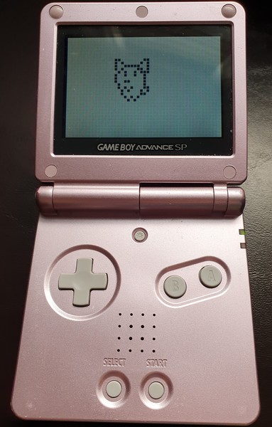 Game Boy Advance SP showing a virtual pet on it, with big pixels