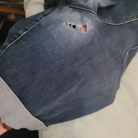 A hole rubbed into the inner thigh area of Mini's denim shorts.