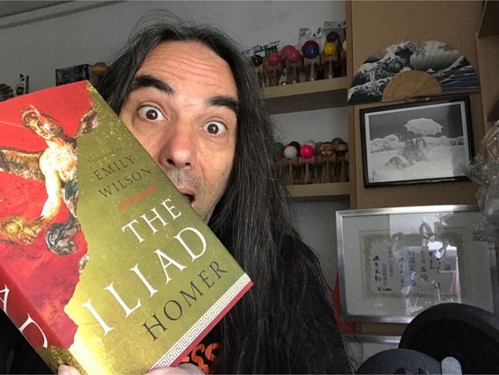 The Void, looking excited whilst holding a copy of Professor Emily Wilson’s new translation of The Iliad.