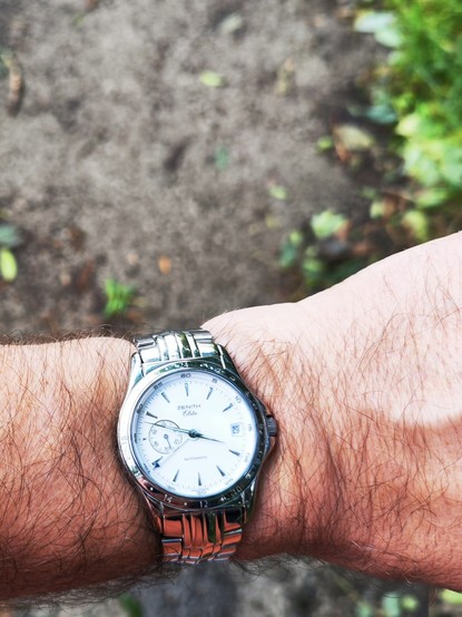 Wrist shot of Zenith Elite GMT dress watch, white dial variant.