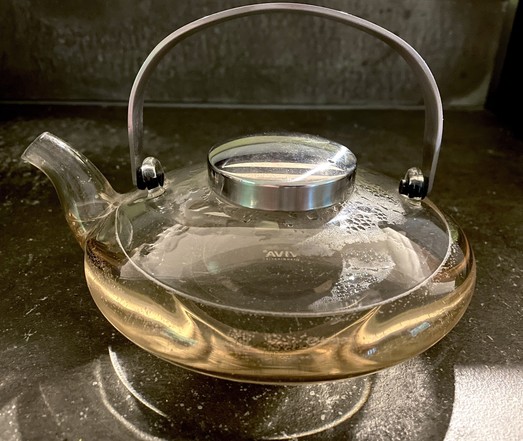 Glass teapot with light, cream soda-colored tea.