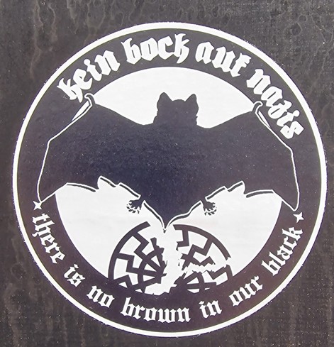 Schwarz weißer Aufkleber mit dem Text und einer Fledermaus mit kaputten nazisymbol