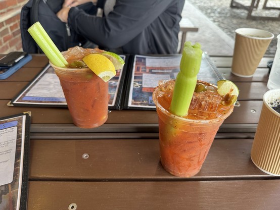 Two Bloody Mary cocktails on an outdoor restaurant table.