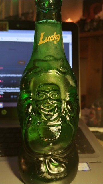 Green glass bottle of Lucky Buddha beer, the glass actually shaped like a smiling, rotund Buddha!