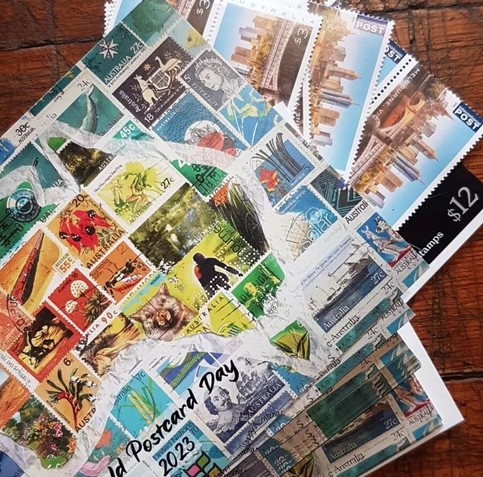 A stack of postcards showing a map of Australia made from old stamps. The cards are artfully arranged on the diagonal to show some sheets of postage stamps as well.