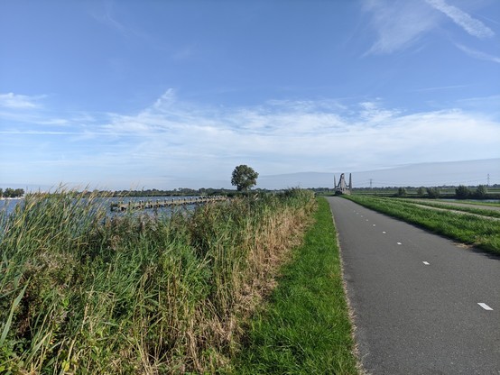 Bicycle road next to river with a blue sky