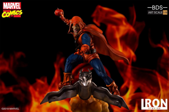 photo of statue of Hobgoblin, wearing his orange cape, preparing to throw a pupkin bomb, he is on his hover jet thing and there's fire int he background