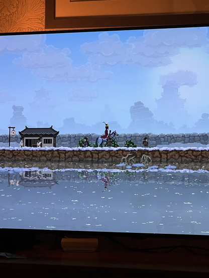 A pixel art game shows a king riding his horse amongst his kingdom subjects.
